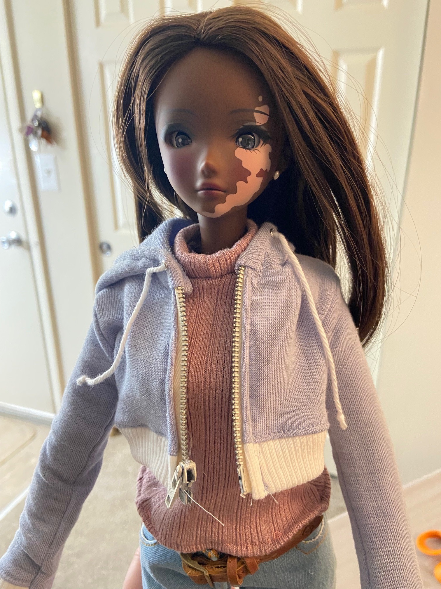 A Smart Doll Liberty in a pink sweater and periwinkle cropped jacket.