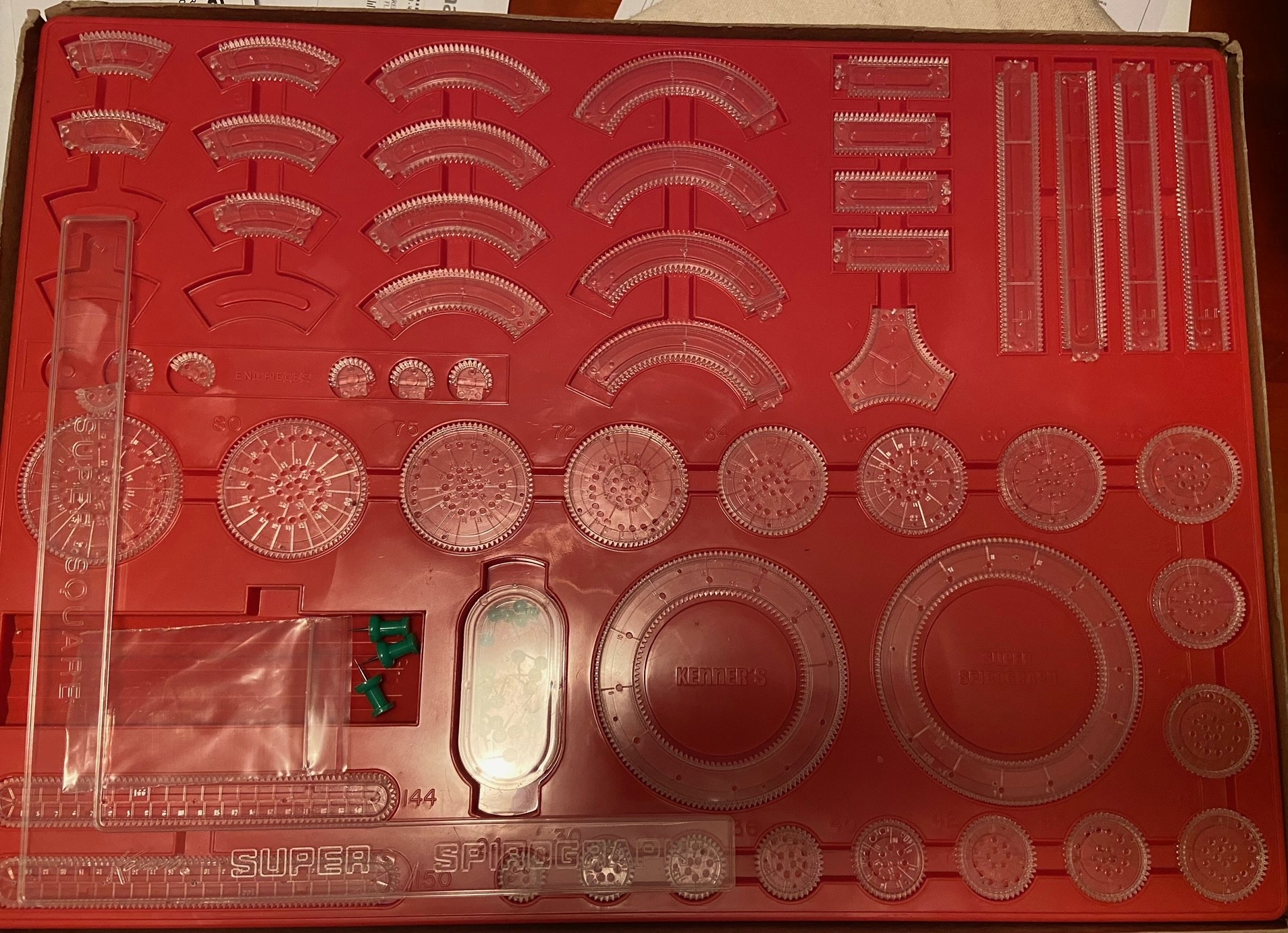 The inside of the Super Spirograph box, containing a full set of pieces.